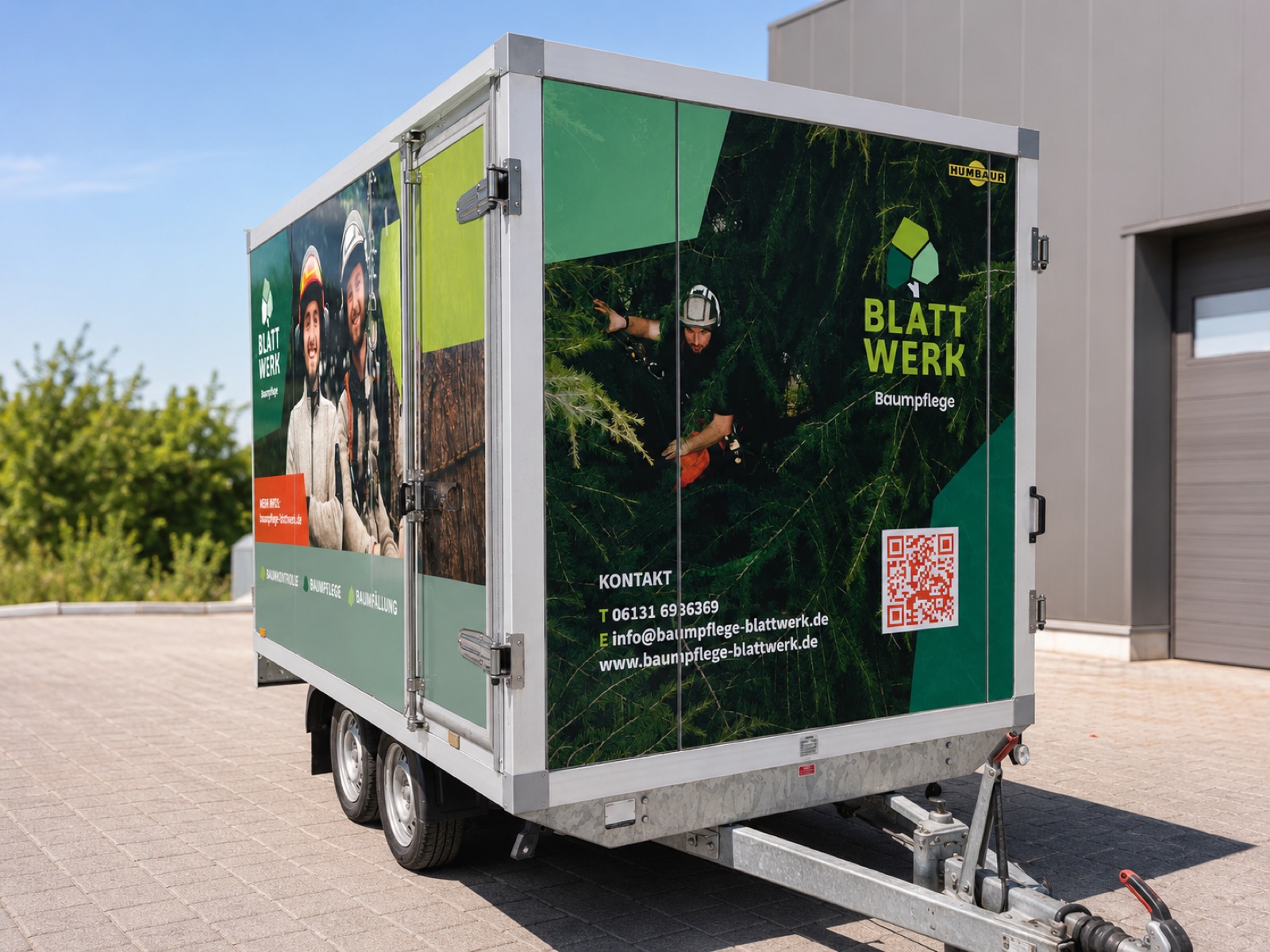 Blattwerk Anhängerfolierung – Heckansicht 3/4 mit Logo und QR-Code